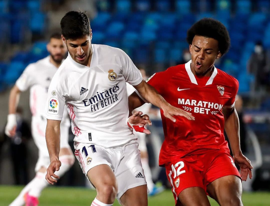 Marco Asensio (kiri) dikawal pemain Sevilla. IG Madrid