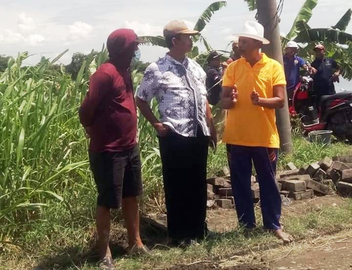 Kepala Desa Bringkan Kecamatan Menganti Kabupaten Gresik Sukarno (tengah) di lokasi jalan rusak. HMP/ONO