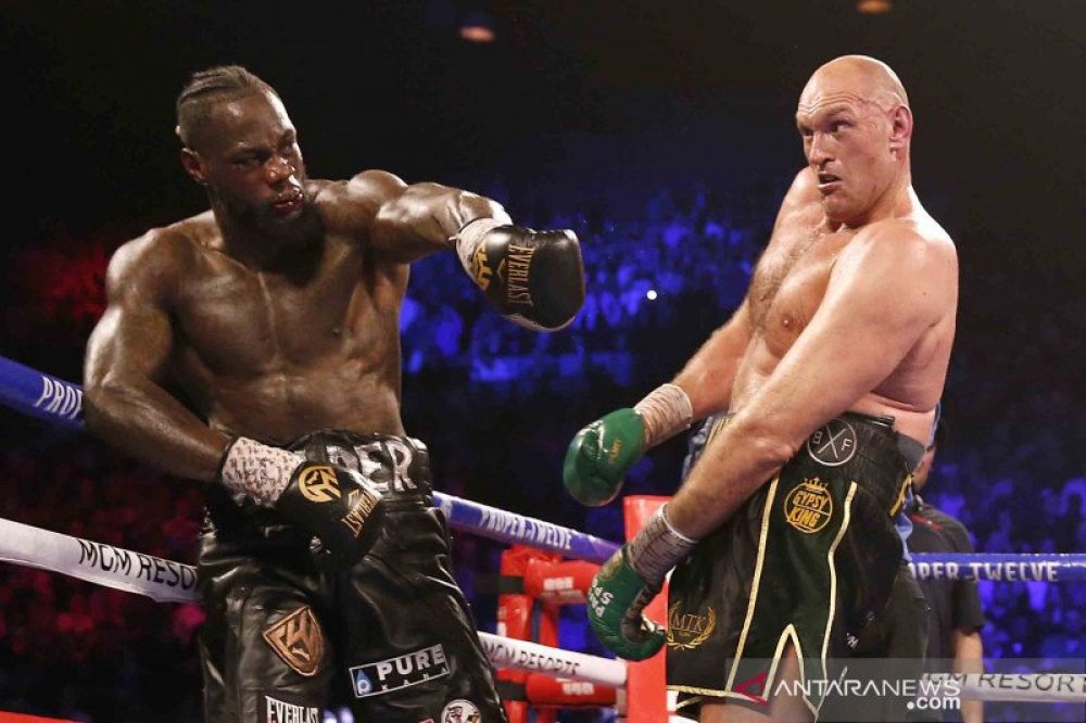 Petinju asal Amerika Serikat Deontay Wilder (kiri) melancarkan pukulan ke arah Petinju asal Inggris Tyson Fury pada pertandingan perebutan sabuk juara kelas berat versi WBC di The Grand Garden Arena, MGM Grand, Las Vegas, Amerika Serikat, Sabtu (22/2/2020