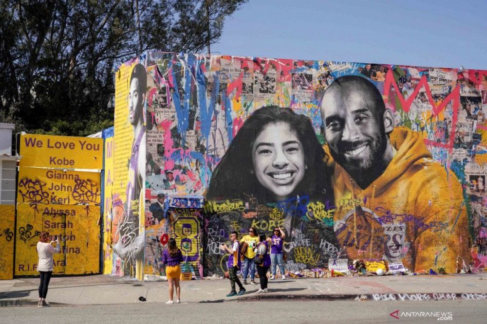 BINTANG NBA: Warga berkumpul di dekat mural saat acara tribut mengenang mendiang legenda basket NBA Kobe Bryant, putrinya Gianna dan tujuh orang lainnya yang meninggal dunia di sebuah kecelakaan helikopter, di Staples Center, Los Angeles, Amerika Serikat,