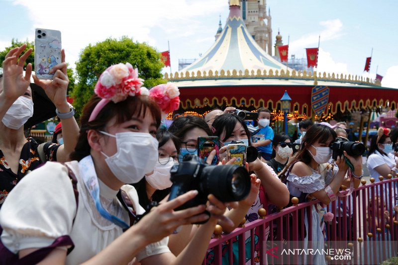 Pengunjung mengenakan masker saat bermain di taman hiburan Disneyland yang dibuka kembali setelah sebelumnya ditutup akibat pandemi COVID-19, Hong Kong, China, Kamis (18/6/2020). ANTARA FOTO/REUTERS/Tyrone/foc.