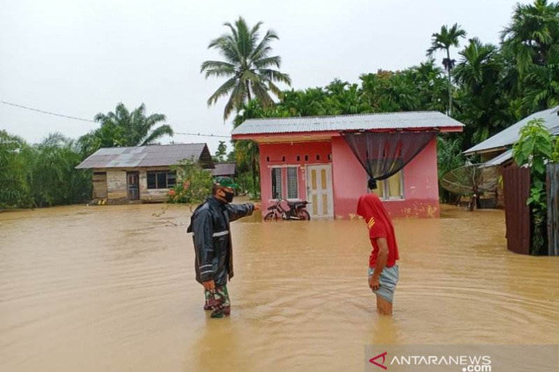 Seorang prajurit TNI berusaha membantu masyarakat yang terdampak banjir di Kecamatan Panga, Kabupaten Aceh Jaya, Selasa (28/7/2020). (ANTARA/HO.Dok BPBD Aceh Jaya)