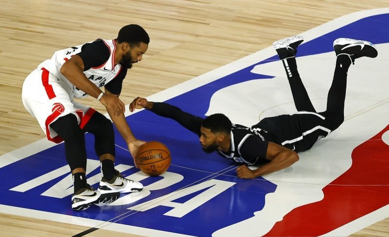 Guard Toronto Raptors Norman Powell (kiri) merebut bola dari penguasaan pemain Brooklyn Nets Garrett Temple dalam gim kedua putaran pertama playoff NBA Wilayah Timur di The Field House, Orlando, Florida, Amerika Serikat, Rabu (19/8/2020) waktu setempat. (