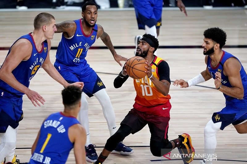 Guard Utah Jazz Mike Conley (kedua kanan) berusaha melepaskan tembakan di tengah kawalan ketat sejumlah pemain Denver Nuggets dalam gim ketiga putaran pertama playoff NBA Wilayah Barat di AdventHealth Arena, Orlando, Florida, Amerika Serikat, Jumat (21/8/