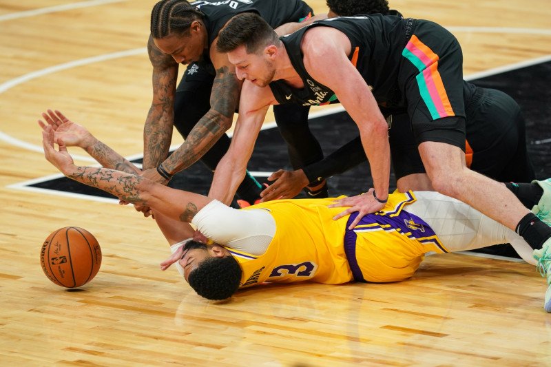 Forward Los Angeles Lakers Anthony Davis (3) berjibaku berebut bola dengan guard San Antonio Spurs DeMar DeRozan (10) and forward Drew Eubanks (14) dalam pertandingan NBA, Jumat (1/1/2021). ANTARA/REUTERS/Daniel Dunn-USA TODAY Sports.

