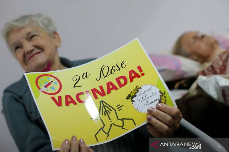 Seorang warga lanjut usia memegang kertas bertuliskan: "Dosis kedua. Vaksinasi!" setelah menerima dosis kedua vaksin COVID-19 Sinovac di panti jompo Solar das Acacias, di Guarulho dekat Sao Paulo, Brazil, (26/2/2021). ANTARA FOTO/REUTERS / Carla Carniel/a
