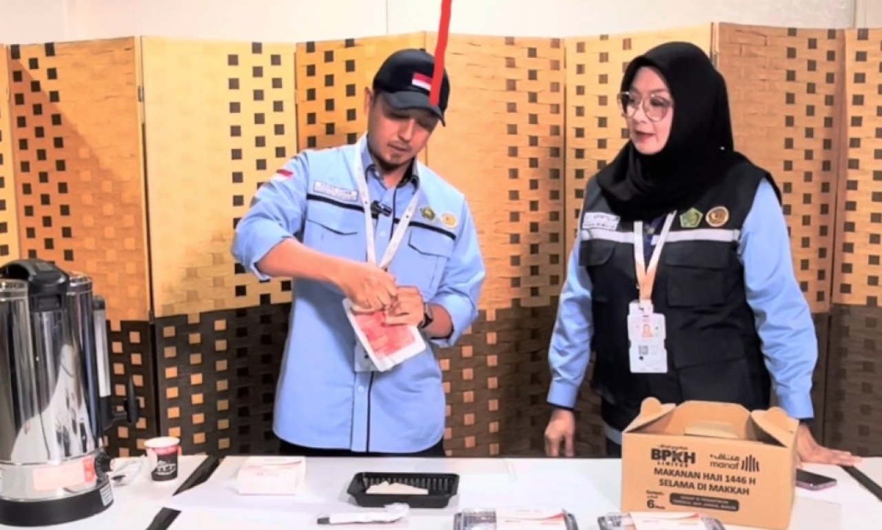 Petugas Layanan Catering PPIH Arab Saudi tengah mempraktikkan cara mengonsumsi makanan siap saji.