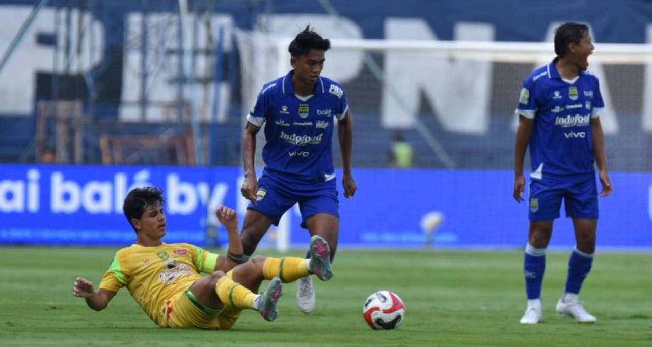 Bek PERSIB, Kakang Rudianto diadang pemain Persebaya pada pertandingan pekan kelima Super League 2025/36 di Stadion Gelora Bandung Lautan Api, Jumat, 12 September 2025. (PERSIB.co.id/Barly Isham)
