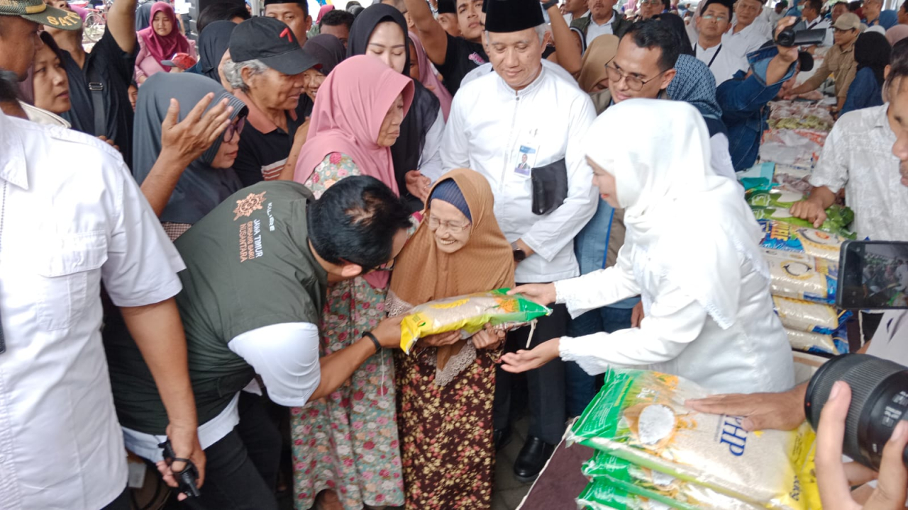 Gubernur Jawa Timur Khofifah Indar Parawansa saat membagikan beras SPHP secara gratis kepada masyarakat lanjut usia atau lansia di rest area Bululawang, Kabupaten Malang, Rabu (22/10/2025)