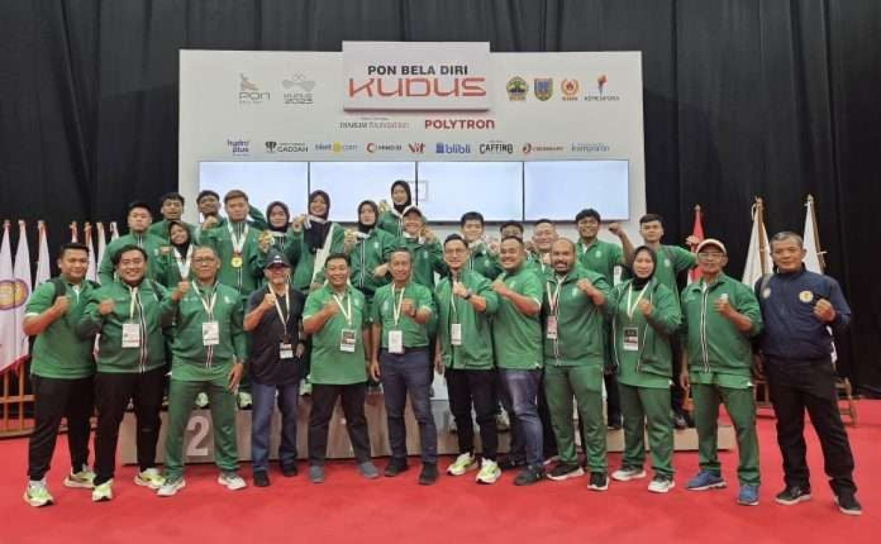 Wakil Ketua KONI Jatim, Irmantara Subagja (tengah) bersama jajaran dan tim Jujitsu Jatim yang menjadi juara umum di PON Bela Diri 2025