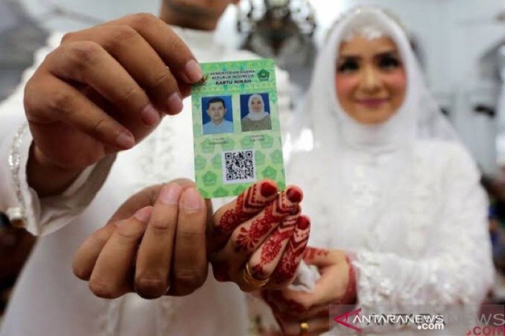  Ilustrasi - Pasangan pengantin memperlihatkan kartu nikah usai melaksanakan ijab kabul di Masjid Raya Baiturrahman, Banda Aceh. (FOTO: (HMP/Irwansyah Putra)