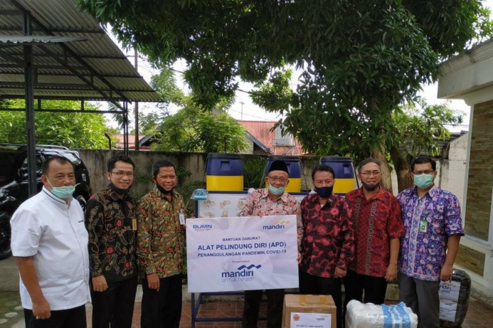Kepala Bank Mandiri Cabang Jambi Suroso menyerahkan bantuan cuci tangan portabel dan alat pelindung diri (APD) kepada Rektor Unjversitas Jambi Prof. Sutrisno. ANTARA/HO-Bank Mandiri Cabang Jambi