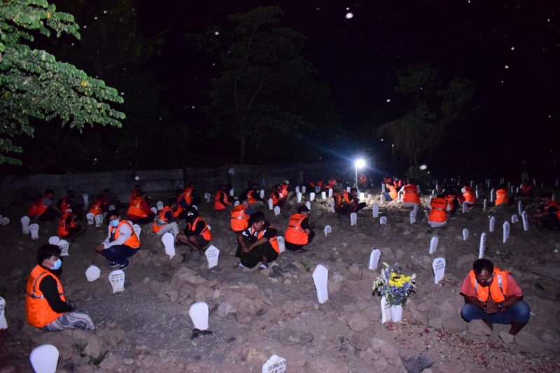 
Pelanggar protokol kesehatan sedang melakukan doa bersama di makam khusus korban COVID-19, di pemakaman Delta Praloyo, Sidoarjo. (Antara Jatim/Polres Sidoarjo/IS) 
