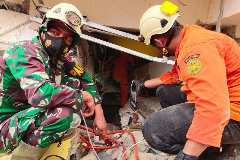Tim Basarnas Kabupaten Mamuju melakukan evakuasi terhadap korban yang masih ada di reruntuhan bangunan yang rubuh dampak gempa berkekuatan 6,2 magnitudo di Kabupaten Mamuju, Provinsi Sulawesi Barat, Jumat (15/1/2021). FOTO/HO/Dokumentasi Basarnas Mamuju.