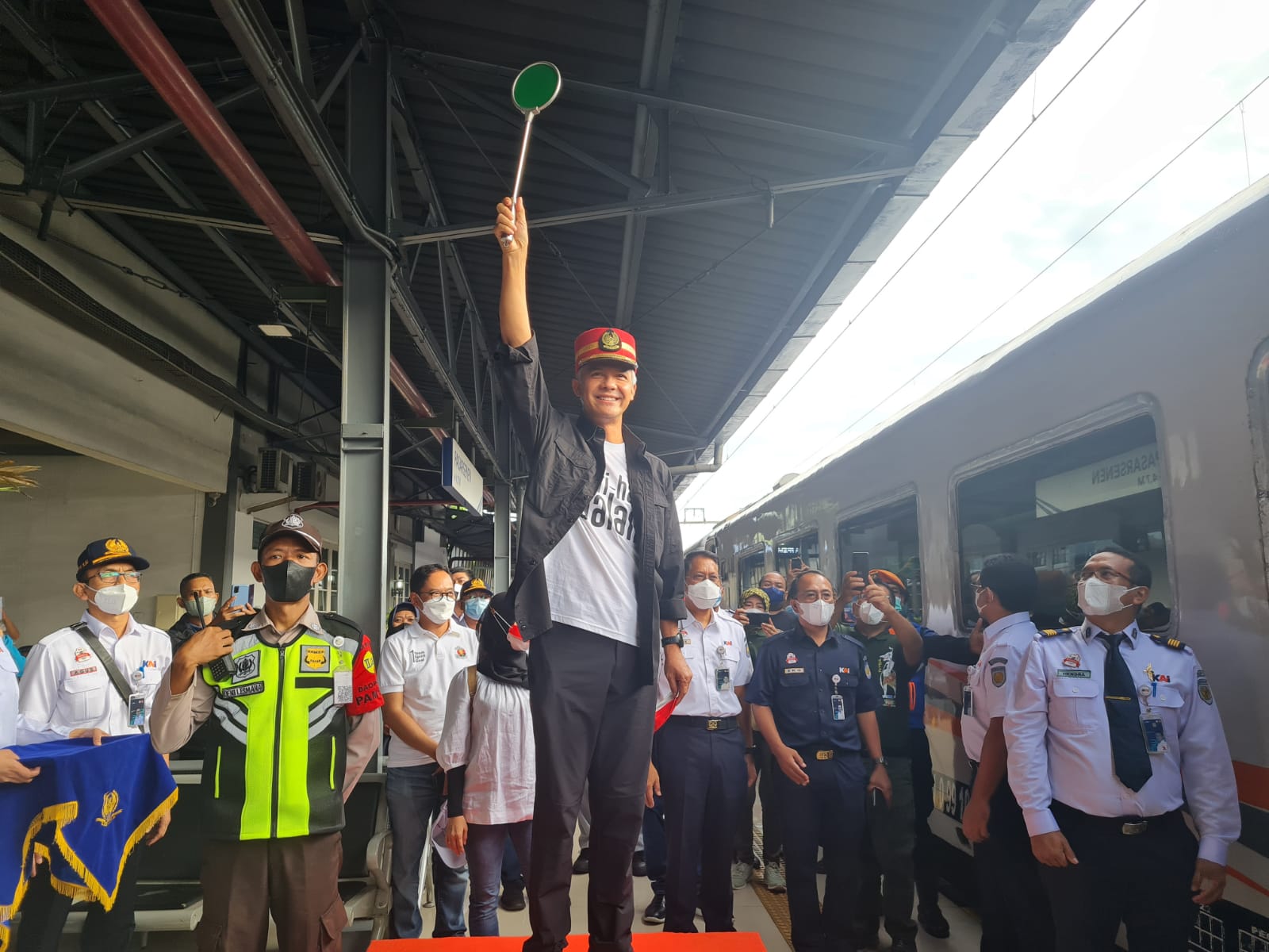 Gubernur Jawa Tengah Ganjar Pranowo mengenakan topi pet merah pengatur perjalanan untuk melepas Mudik Gratis Lebaran 2022 melalui jalur kereta api, Jumat (29/4/2022).