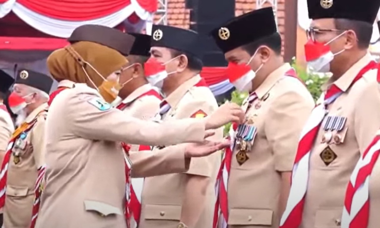 Gubernur Jawa Timur Khofifah Indar Parawansa saat menyematkan Tanda Penghargaan Teladan Daerah Gerakan Pramuka kepada Nur Kholis di halaman Gedung Negara Grahadi Surabaya, Minggu (14/8) 