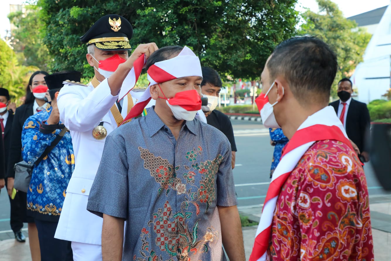 Gubernur Jawa Tengah Ganjar Pranowo menyematkan kain merah putih ke Joko Priyono alias Karso asal Kota Semarang , eksnarapidana teroris usai mengikuti upacara bendera dalam peringatan Hari Ulang Tahun (HUT) ke-77 Republik Indonesia di Lapangan Pancasila S