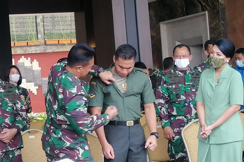 Kasad Jenderal TNI Andika Perkasa bersama istrinya Hetty Andika Perkasa saat mengganti tanda pengenal Serda Aprilio Perkasa Manganang di Mabesad, Jakarta, Jumat (19-3-2021). (ANTARA/Syaiful Hakim)

