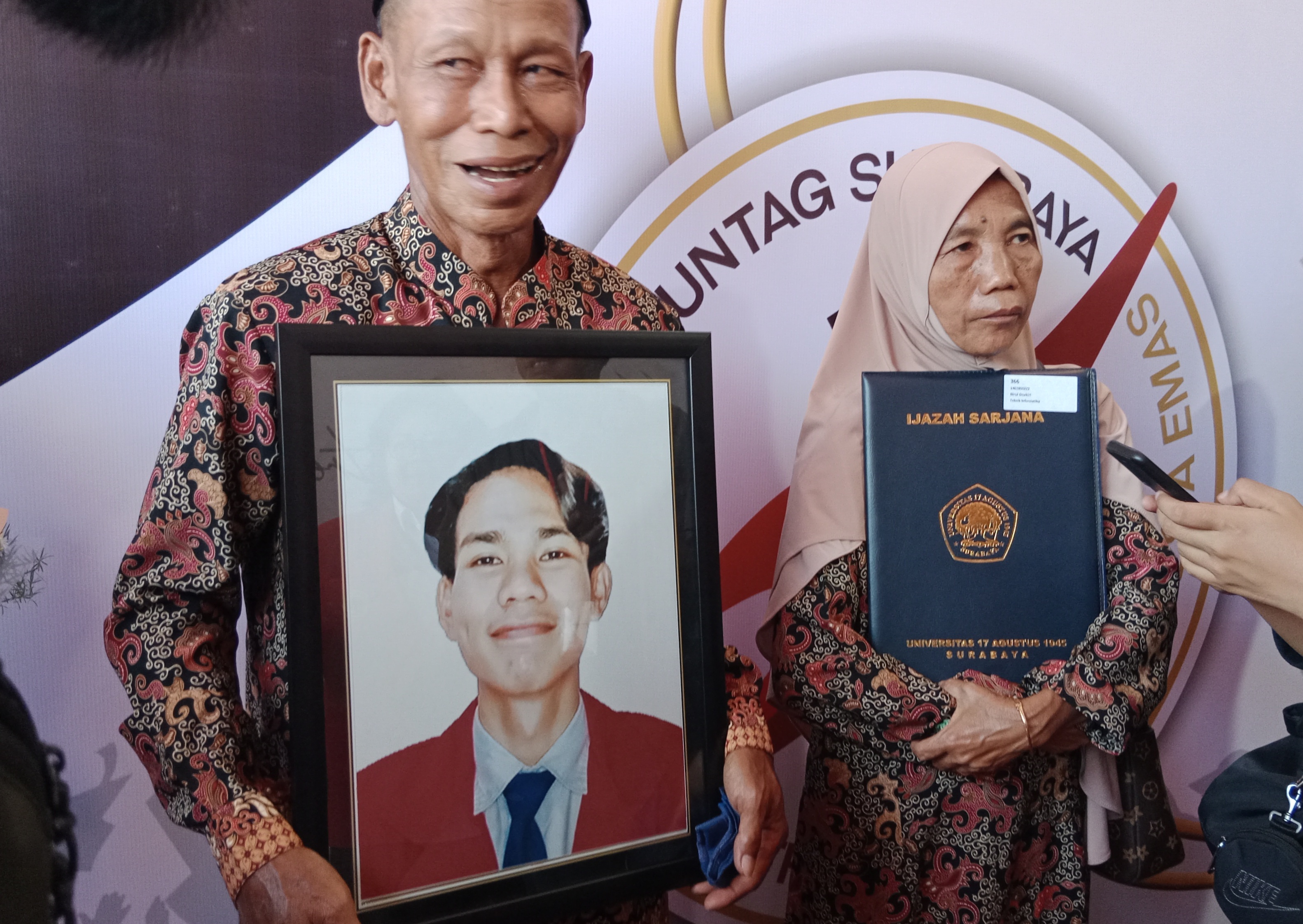 Mustain dan Marodik, orang tua dari almarhum Birul Dzakiri hadir di wisuda dengan membawa foto putra tercinta pada wisuda ke-129 Universitas 17 Agustus 1945 