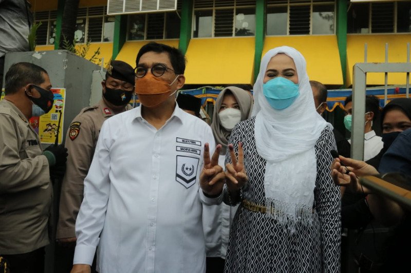 Calon Wali Kota Surabaya Machfud Arifin bersama istrinya Lita menggunakan hak pilihnya di Pilkada 2020 dengan mencoblos di TPS 25 Jalan WR Supratman Nomor 46 Kota Surabaya, Jatim, Rabu (8/12/2020). (FOTO ANTARA/Abdul Hakim)