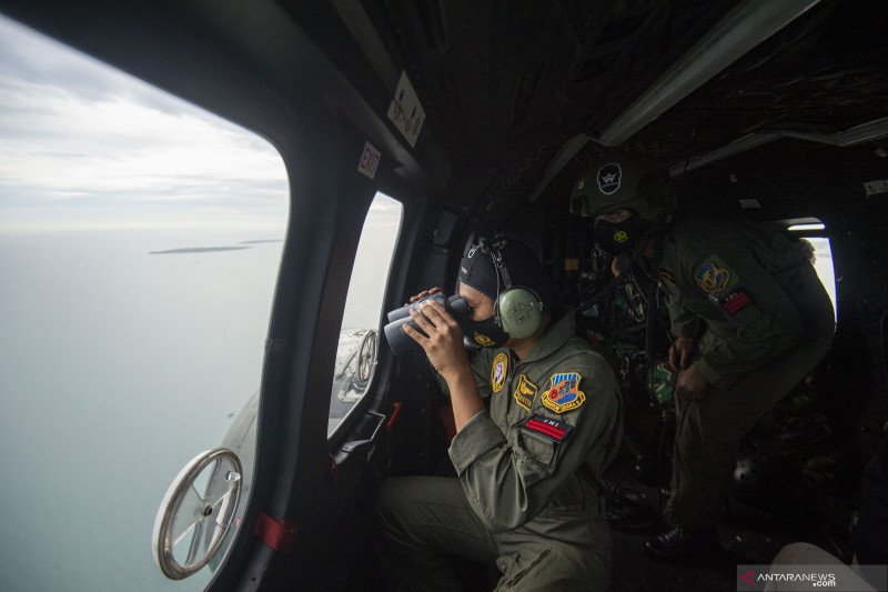 Prajurit TNI AU melakukan pencarian korban dan puing pesawat Sriwijaya Air SJ 182 dari helikopter NAS-332 Super Puma dengan pilot Letkol Penerbang Risdiyanto dari Skadron Udara 6 Lanud Atang Sendjaja di atas perairan Kepulauan Seribu, Jakarta, Minggu (10/