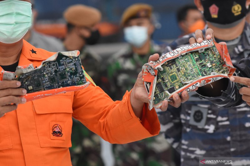 Direktur Operasi Basarnas Brigjen TNI (Mar) Rasman (kiri) menunjukkan kotak penyimpanan memori dari perekam suara kokpit atau Cockpit Voice Recorder (CVR) pesawat Sriwijaya Air PK-CLC nomor penerbangan SJ 182 rute Jakarta - Pontianak yang dibawa oleh KRI 