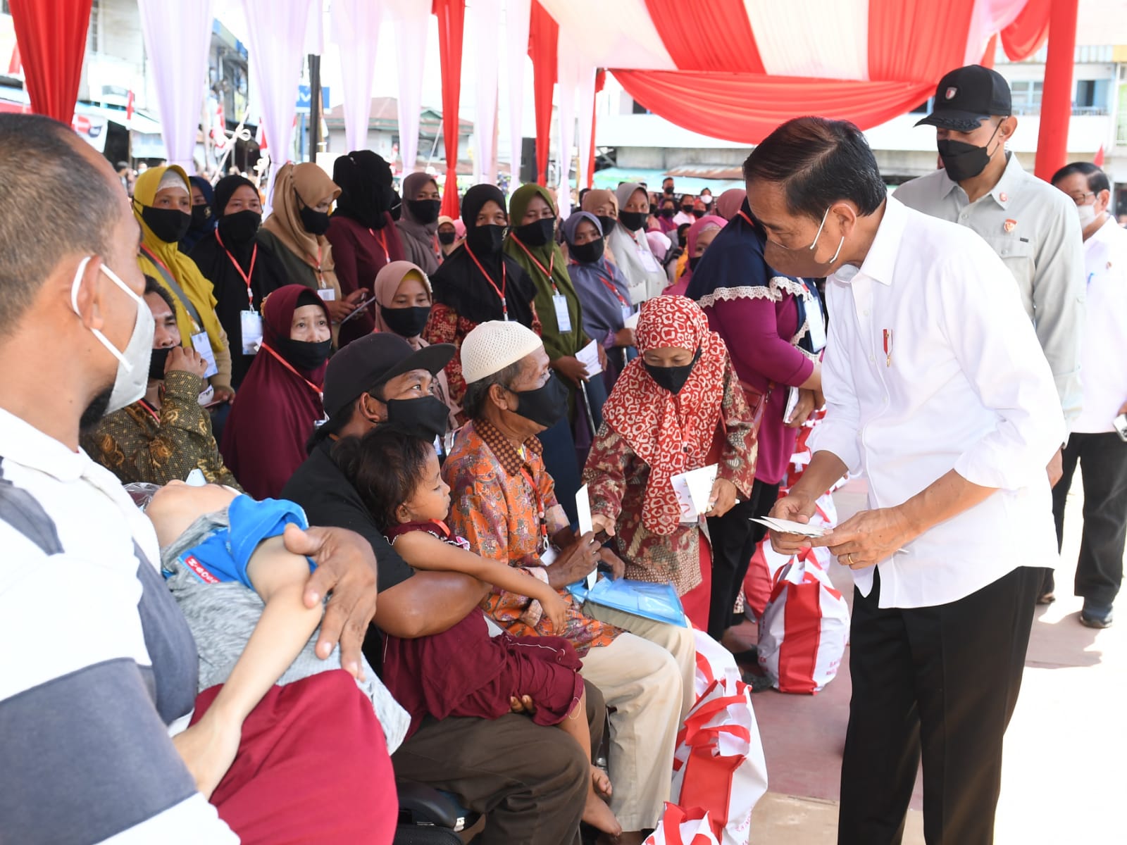 Presiden Jokowi didampingi Ibu Iriana Joko Widodo menyerahkan BMK dan BLT minyak goreng kepada peserta Program Keluarga Harapan (PKH) di Pasar Sungai Duri, Kabupaten Bengkayang, Provinsi Kalimantan Barat, pada Selasa (09/08/2022). (Foto: BPMI Setpres/Kris