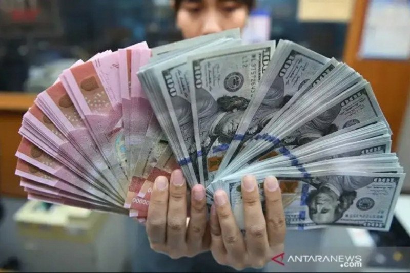 Teller menunjukan rupiah dan dolar di penukaran mata uang asing di Jakarta (ANTARA FOTO)