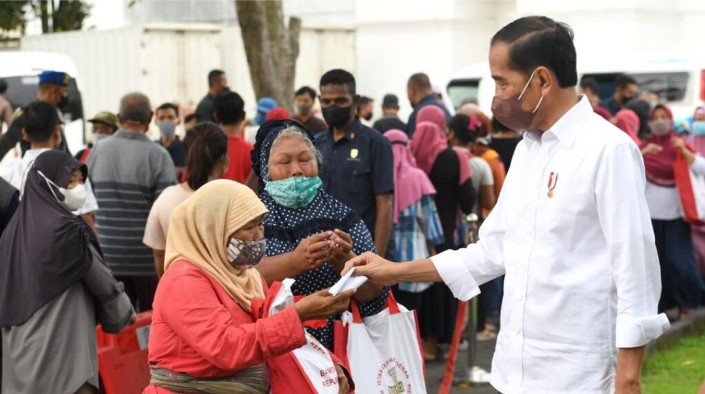 Presiden Joko Widodo membagikan paket sembako bagi masyarakat di sekitar Gedung Agung, Istana Kepresidenan Yogyakarta, pada Sabtu, 30 April 2022. Foto: BPMI Setpres/Lukas