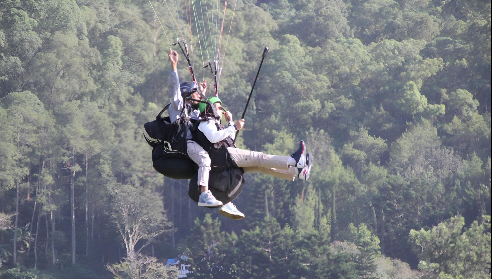 Pj. Gubernur Jawa Timur, Adhy Karyono,  saat mencoba wisata tandem paralayang di Gunung Banyak, Bumiaji, Kota Batu, pada Sabtu (13/7)
