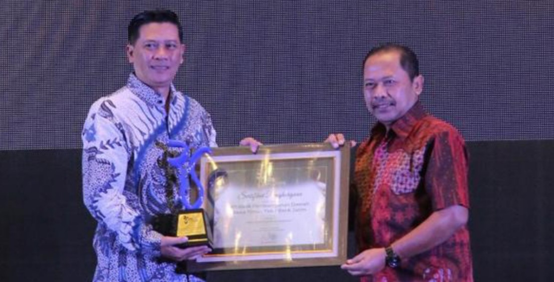 Direktur Radar Surabaya Lilik Widyantoro menyerahkan penghargaan kepada Bank Jatim yang diterima oleh AVP Komunikasi Korporat bankjatim Bambang Supriadi