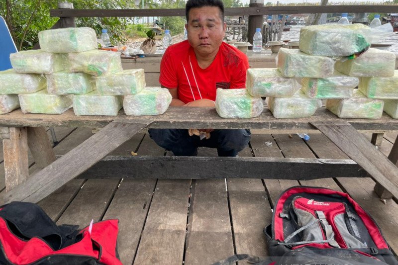 Tersangka dan barang bukti 20 kilogram narkoba jenis sabu yang ditangkap saat penyelundupan dari Malaysia di Rupat, Provinsi Riau, Senin (18/1/2021). (ANTARA/HO-Polda Riau)