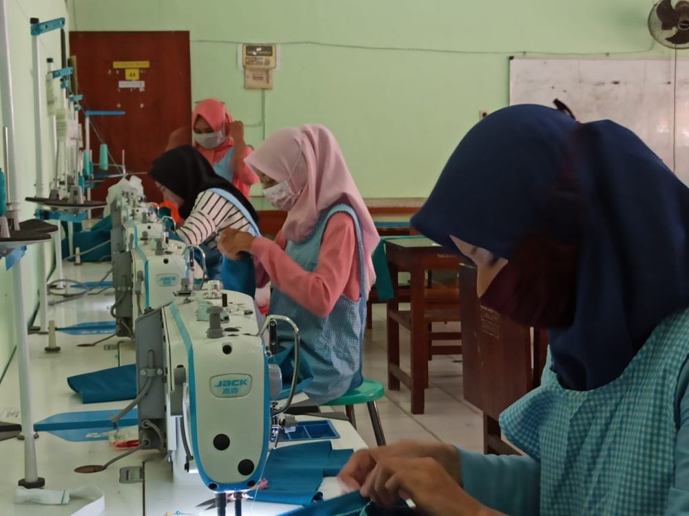 Pelajar SMKN 6 Surabaya saat menjahit baju APD bagi tenaga medis. ( foto: riski )
