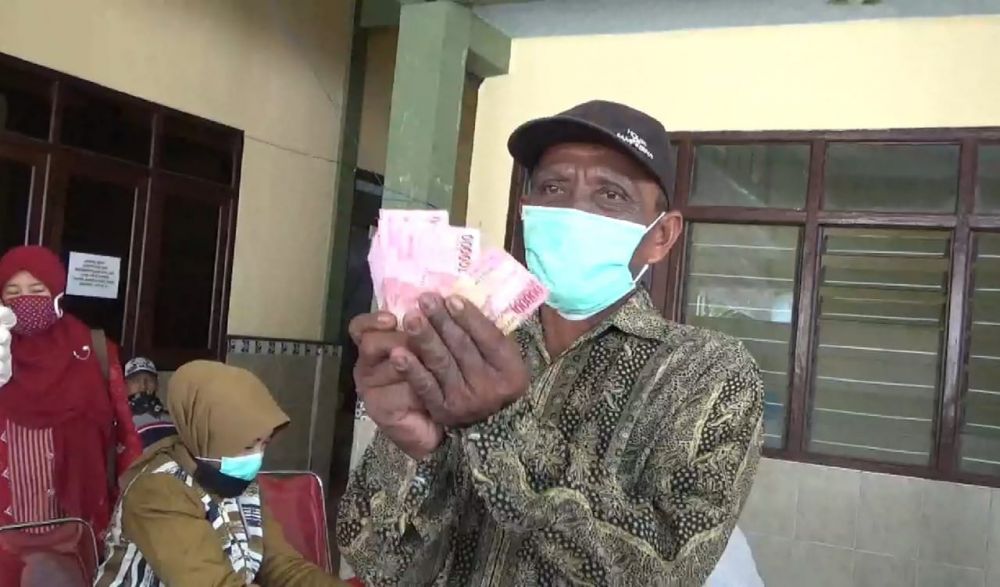 Artam ( 61 ) warga Desa Sidorejo Gresik cukup senang, setelah dapat BLT. ( foto : yar/hmp)