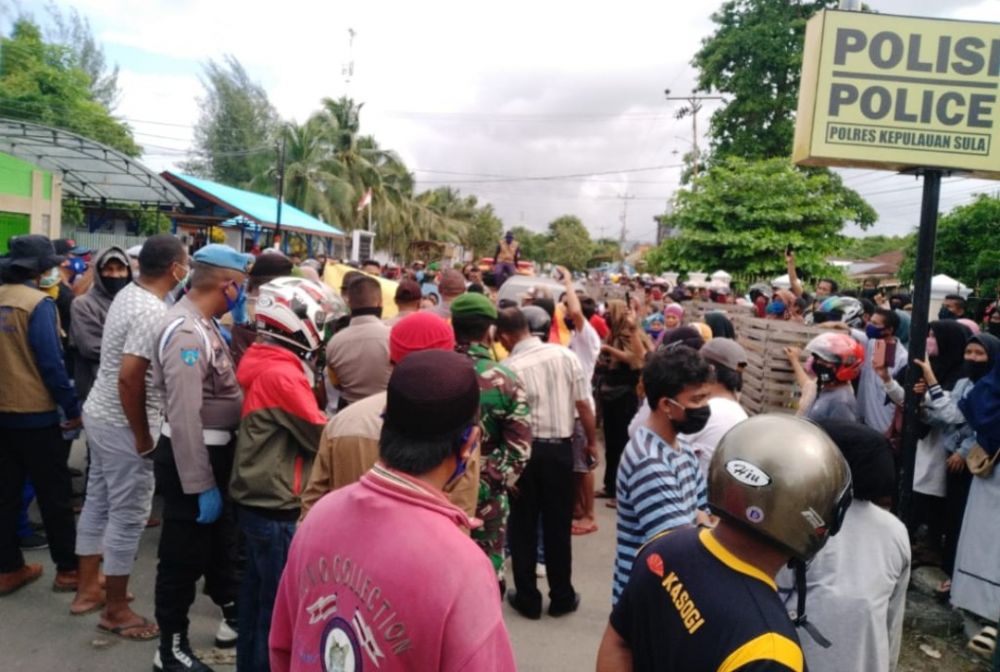 Ratusan warga berkumpul di depan pintu Polres Kepulauan Sula, Senin (8/6).