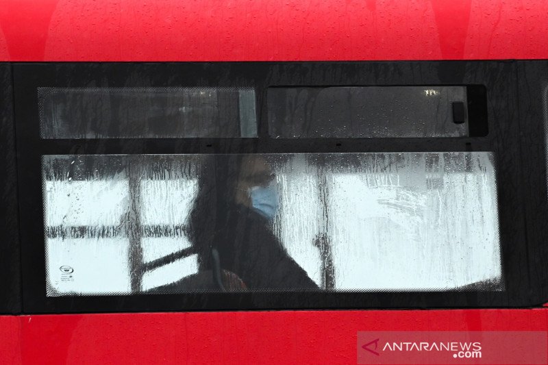 Seorang penumpang bus memakai masker saat 'lockdown', di tengah penyebaran penyakit virus corona (COVID-19), di London, Inggris, Kamis (14/1/2021). ANTARA FOTO/REUTERS/Toby Melville/WSJ/cfo

