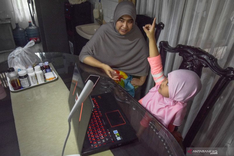 Seorang ibu mendampingi anaknya belajar di rumah saat kegiatan belajar di sekolah dihentikan sementara selama Pembatasan Sosial Berskala Besar (PSBB) untuk mengendalikan penularan COVID-19 di Kota Pekanbaru, Riau, Sabtu (2/5/2020). ANTARA FOTO/FB Anggoro/
