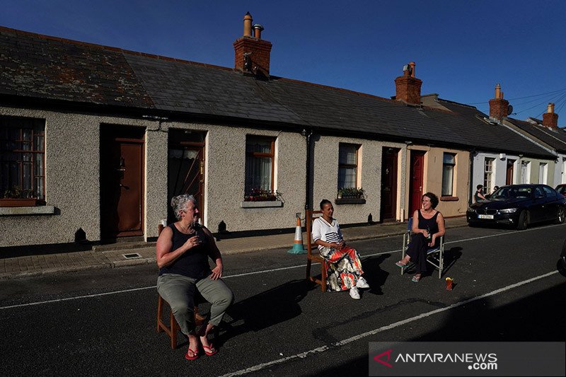 dok/ Warga sekitar menikmati minuman di depan pintu rumah mereka di Dublin, Irlandia, Sabtu (11/4/2020), sambil menjaga jarak setelah pemerintah mengumumkan pembatasan lebih lanjut pergerakan warga di tengah pandemi virus corona (COVID-19). ANTARA/REUTERS