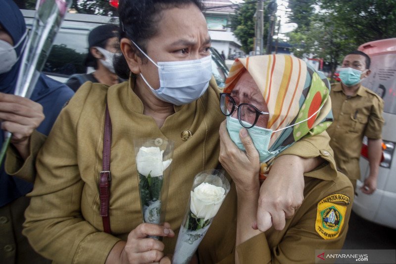 Sejumlah tenaga medis Dinas Kesehatan Kabupaten Bogor terisak tangis saat memberikan penghormatan terakhir kepada jenazah Kepala Puskesmas Banjarsari Dokter Usman, yang meninggal akibat COVID-19 di Jalan Raya Tegar Beriman, Kabupaten Bogor, Jawa Barat, Se