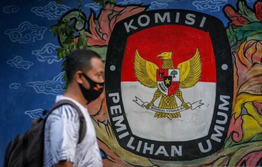 warga melintas di depan mural bertema pemilihan umum di kawasan Pasar Anyar, Tangerang, Banten, Kamis (7/5/2020). Presiden Joko Widodo menunda pemungutan suara Pemilihan Kepala Daerah 2020 hingga Desember 2020 akibat wabah virus Corona. ANTARA FOTO/Fauzan