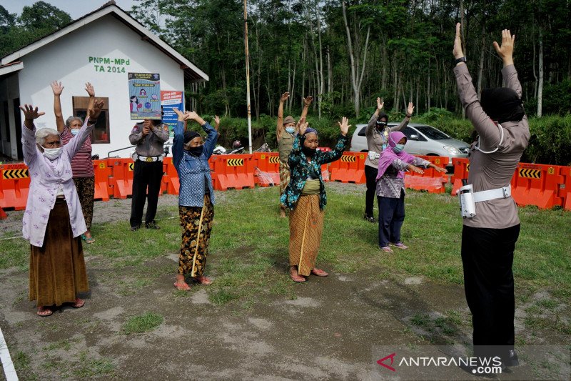 Polisi memandu pengungsi dari lereng Gunung Merapi senam bersama di Barak Pengungsian Glagaharjo, Cangkringan, Sleman, D.I Yogyakarta, Senin (25/1/2021). (ANTARA FOTO/Andreas Fitri Atmoko/wsj)


