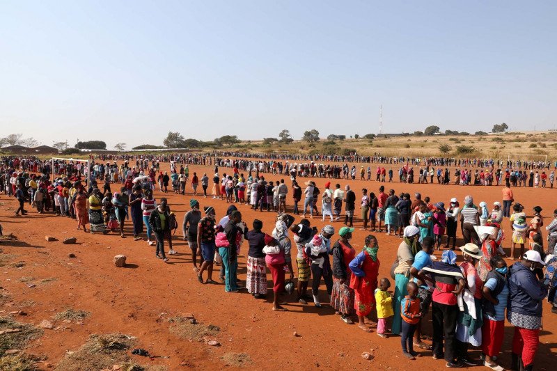 Warga mengantri untuk menerima bantuan makanan di tengah penyebaran penyakit virus korona (COVID-19) di pemukiman informal Itireleng, dekat pinggiran kota Laudium di Pretoria, Afrika Selatan, Rabu (20/5/2020). (REUTERS/SIPHIWE SIBEKO)


