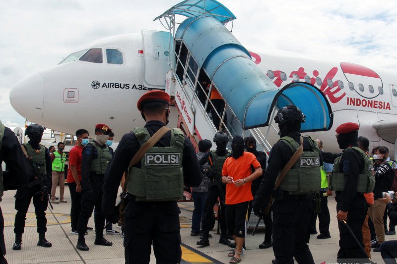 Petugas Detasemen Khusus (Densus) 88 membawa terduga teroris dari Lampung setibanya di Bandara Soekarno Hatta, Tangerang, Banten, Rabu (16/12/2020). Sebanyak 23 orang terduga teroris jaringan Jamaah Islamiyah (JI) yang ditangkap di Lampung dibawa ke Jakar
