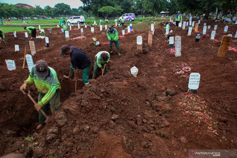 Petugas menggali liang lahat untuk jenzah COVID-19 di TPU Bambu Apus, Jakarta, Minggu (24/1/2021). (ANTARA FOTO/Fauzan/foc)

