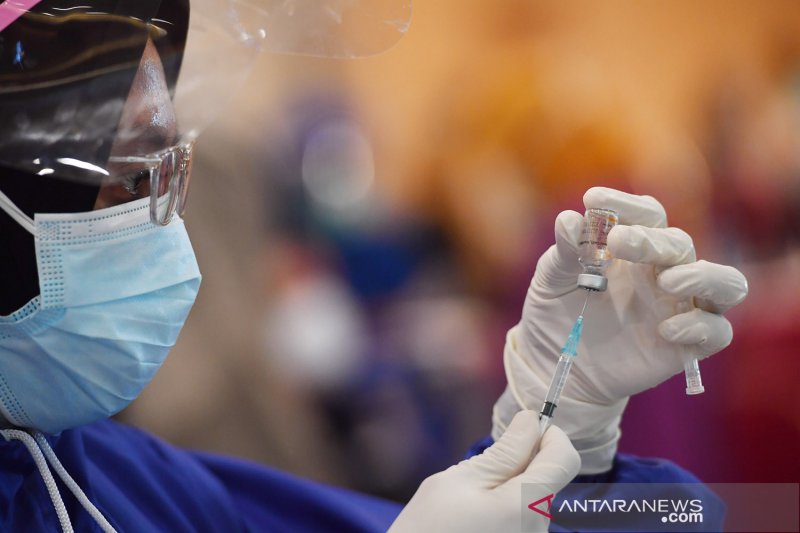 Petugas bersiap menyuntikkan vaksin COVID-19 produksi Sinovac kepada penerima vaksin saat pelaksanaan vaksinasi massal di Surabaya, Jawa Timur, Minggu (31/1/2021).Vaksinasi massal tersebut diikuti kurang lebih 5.000 tenaga kesehatan. ANTARA FOTO/Zabur Kar