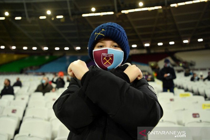 Penggemar West Ham United memakai masker di dalam stadion sebelum pertandingan Liga Primer antara West Ham United melawan Manchester Uniter dimulai di London Stadium, London, Inggris, Sabtu (5/12/2020). Pertandingan hanya boleh dihadiri sejumlah terbatas 
