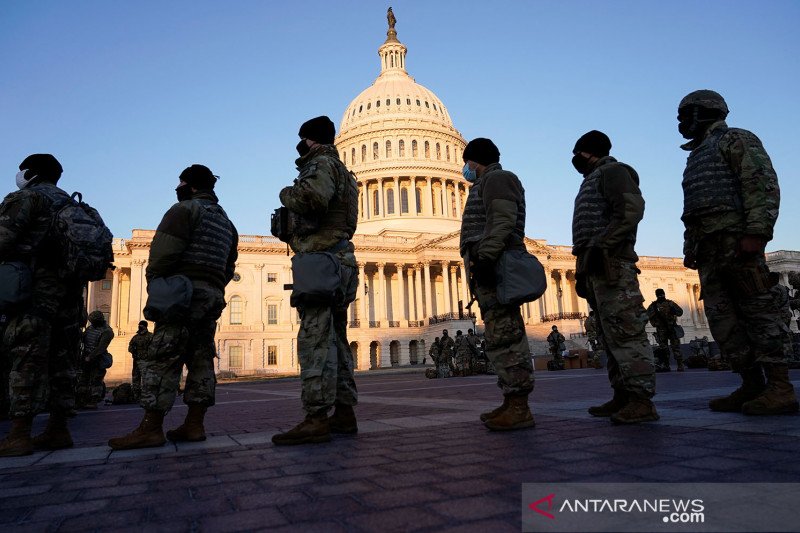 Anggota Garda Nasional diberikan senjata sebelum Demokrat memulai debat tentang satu pasal pemakzulan terhadap Presiden Amerika Serikat Donald Trump di U.S. Capitol, di Washington, Amerika Serikat, Rabu (13/1/2021). REUTERS/Joshua Roberts/aww/cfo (REUTERS