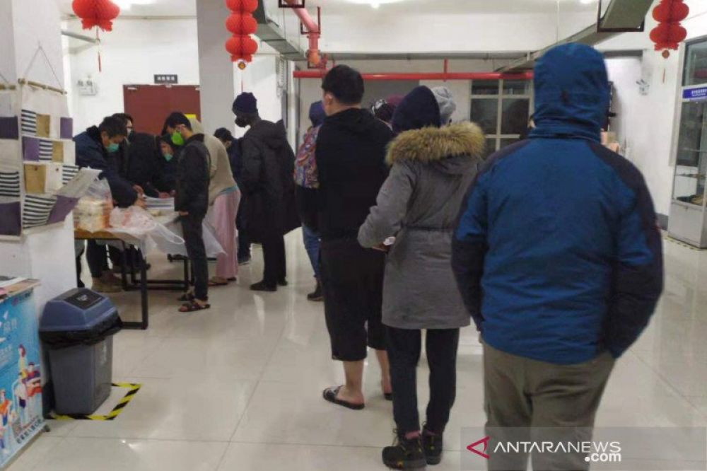 Para pelajar dari Indonesia dan negara lain antre membeli makanan di sekitar kampus asrama di Wuhan, Provinsi Hubei, China, Senin (27/1/2020) (ANTARA/HO-PPIT Wuhan/mii)