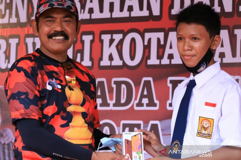 Wali Kota Surakarta FX Hadi Rudyatmo saat menyerahkan gawai kepada salah satu siswa SMP di Kota Solo. (ANTARA/Aris Wasita)