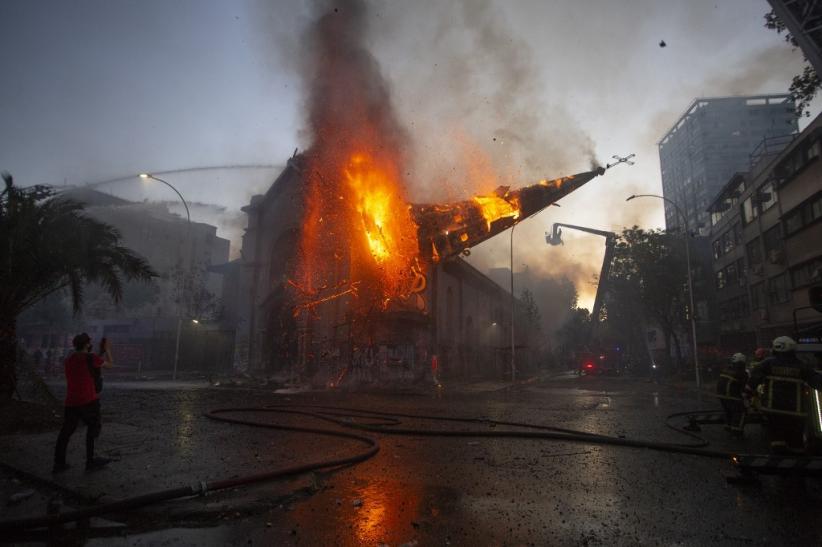 Gereja Asuncion di Santiago Cile dibakar massa demonstran, Minggu (18/10) pertang waktu setempat. (Foto: AFP)